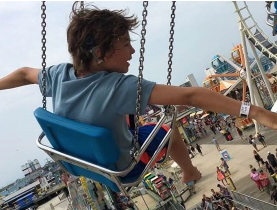 Young boy in swing at amusement park