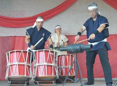 Group of three people playing Taiko drumming