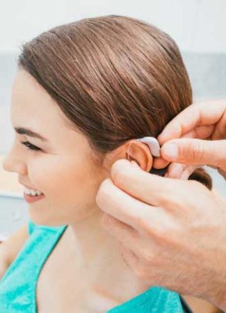 Young woman be fitted with hearing aid