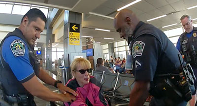 Karen McGee at the airport being escorted out