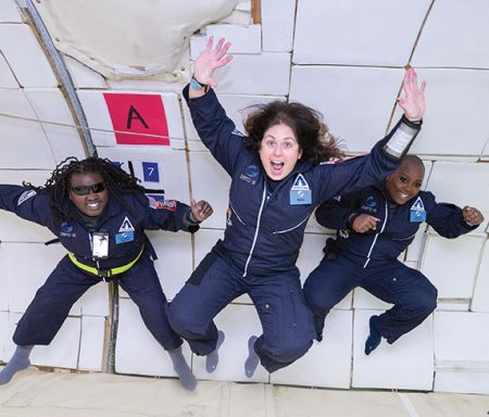 Three members of the AstroAccess team floating in space