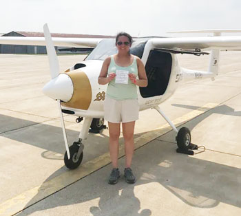 Photo of Sheila Xu with pilot license and glider